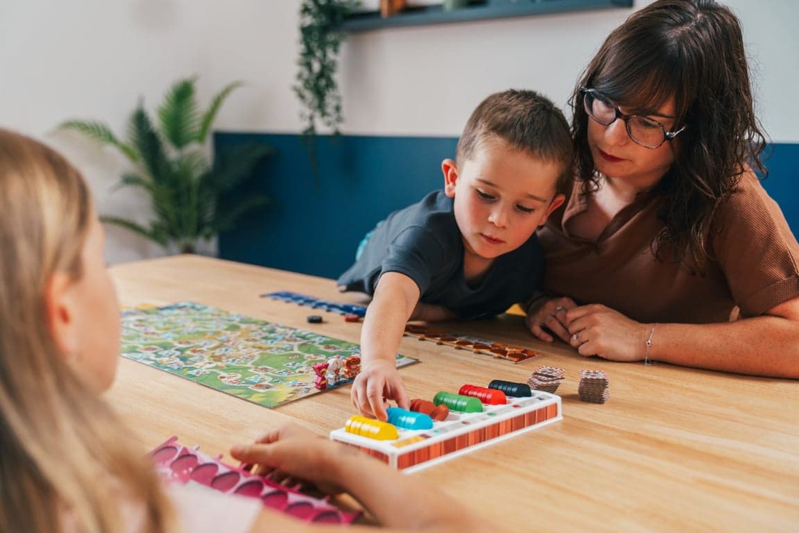 Moeder en zoon spelen samen Splendor Kids aan tafel