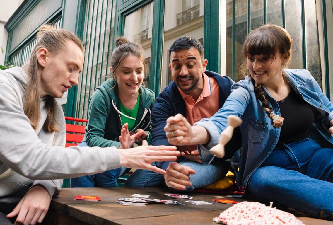 Vrienden grijpen tegelijk naar de totem van Jungle Speed